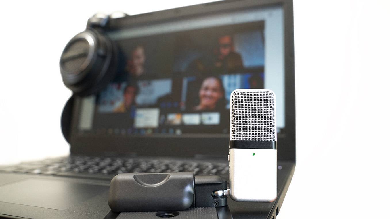A microphone set up in front of an online group video call