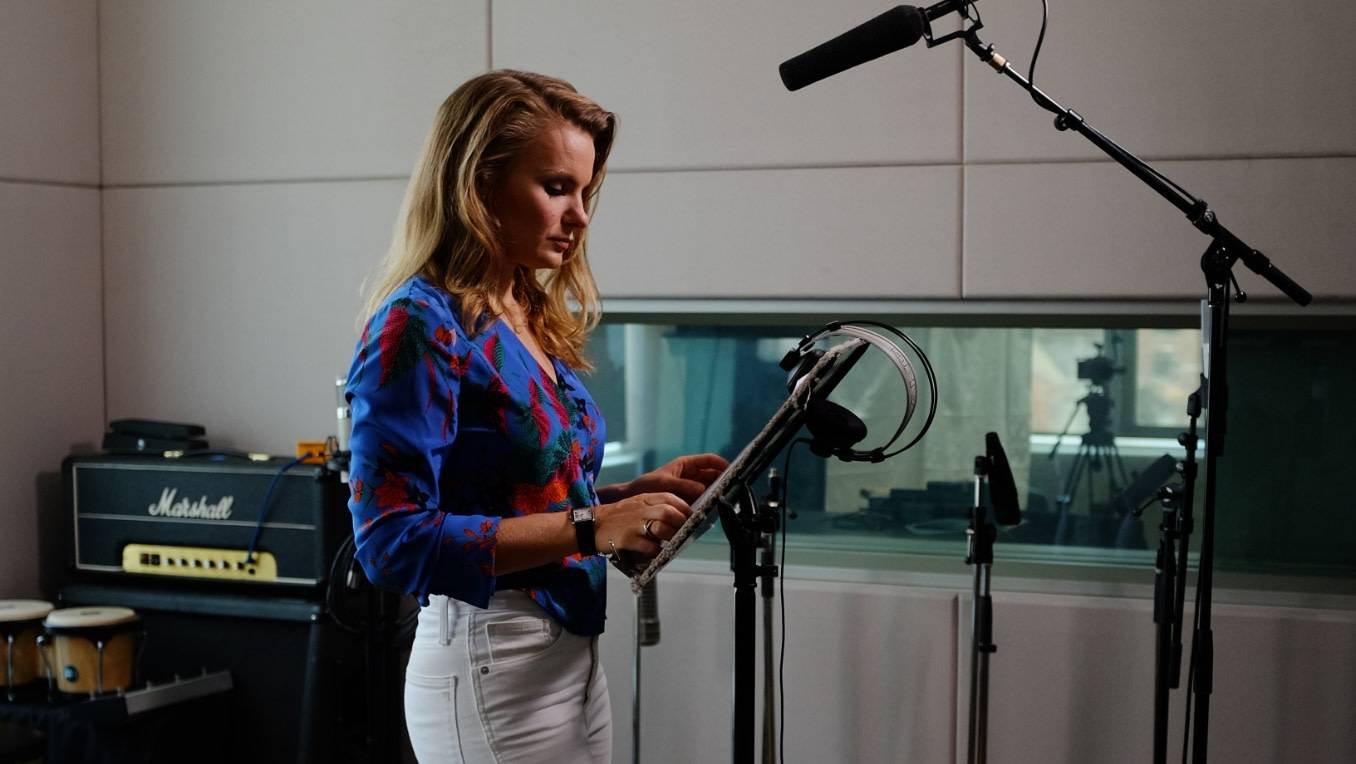 Michele Romanow stands in a recording studio preparing to give a performance
