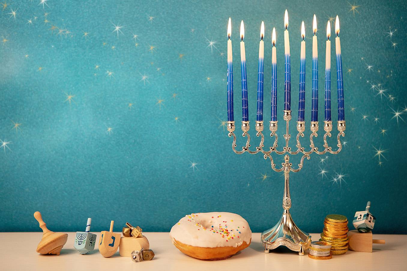 A table is adorned with various symbols of Hannukah including a menorah and dreidels