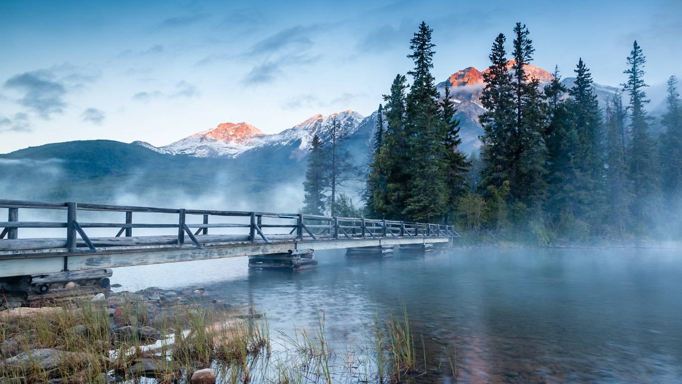 A photograph of morning mist over Pyramid lake in Jasper Alberta