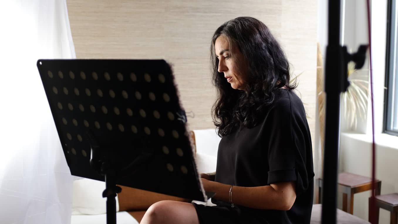 Tanya Talaga sits in a home recording studio in front of a microphone
