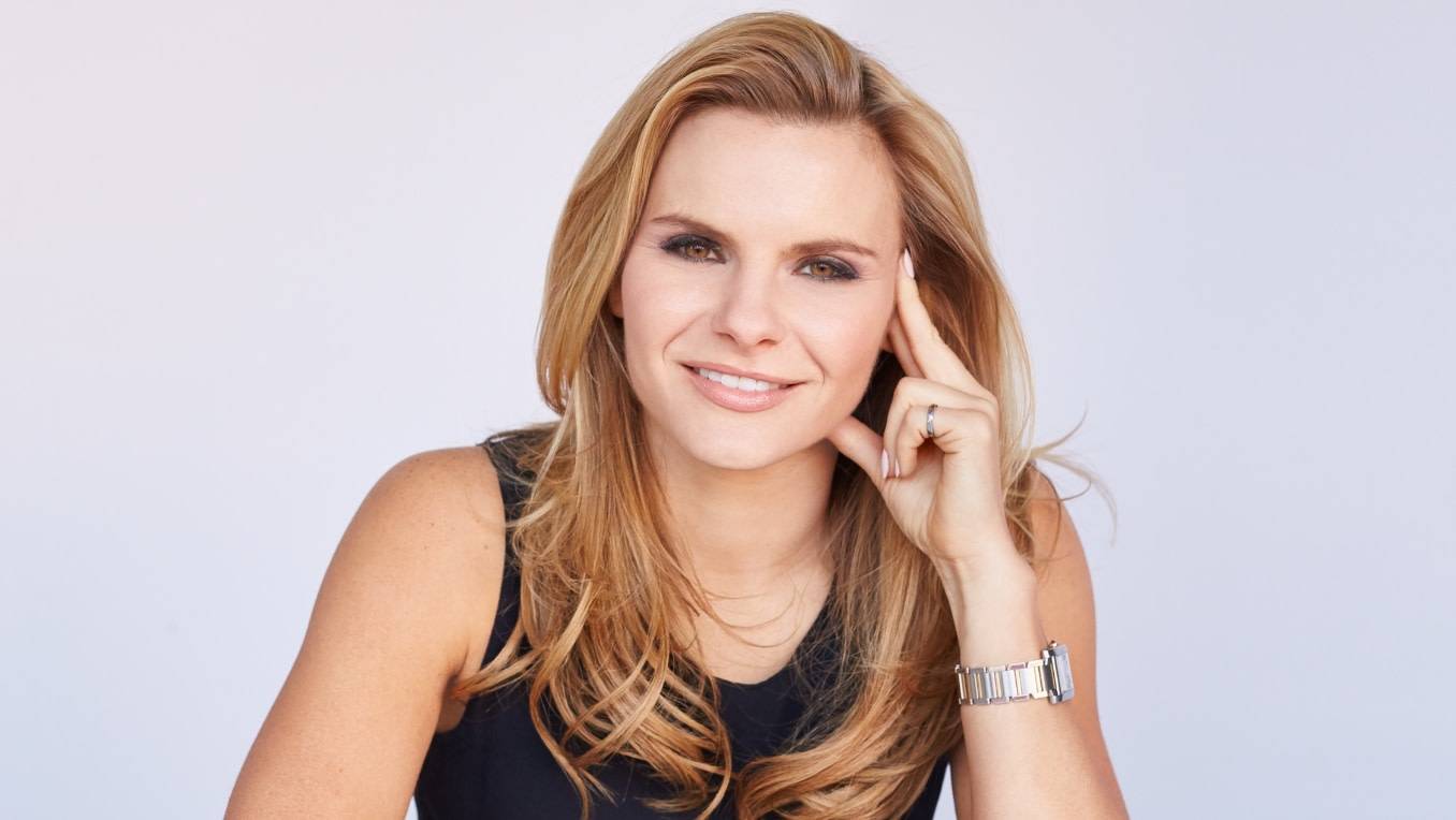 A photo of Michele Romanow sitting casually at a table