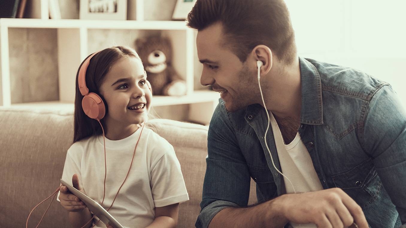 Une enfant et son père écoutent ensemble des livres audio