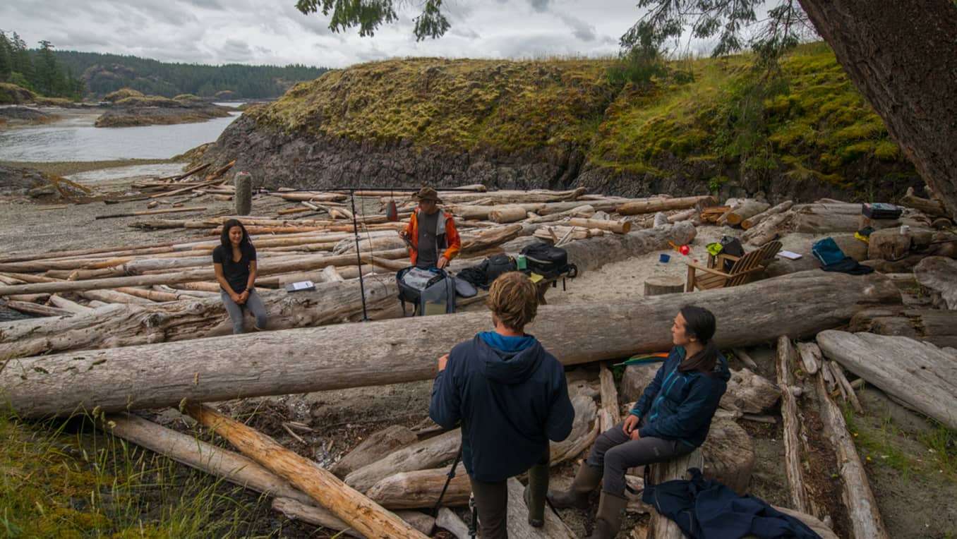 Sarika Cullis-Suzuki assise sur un tronc d’arbre pendant l’enregistrement de la série audio Paysage sonore de la nature canadienne