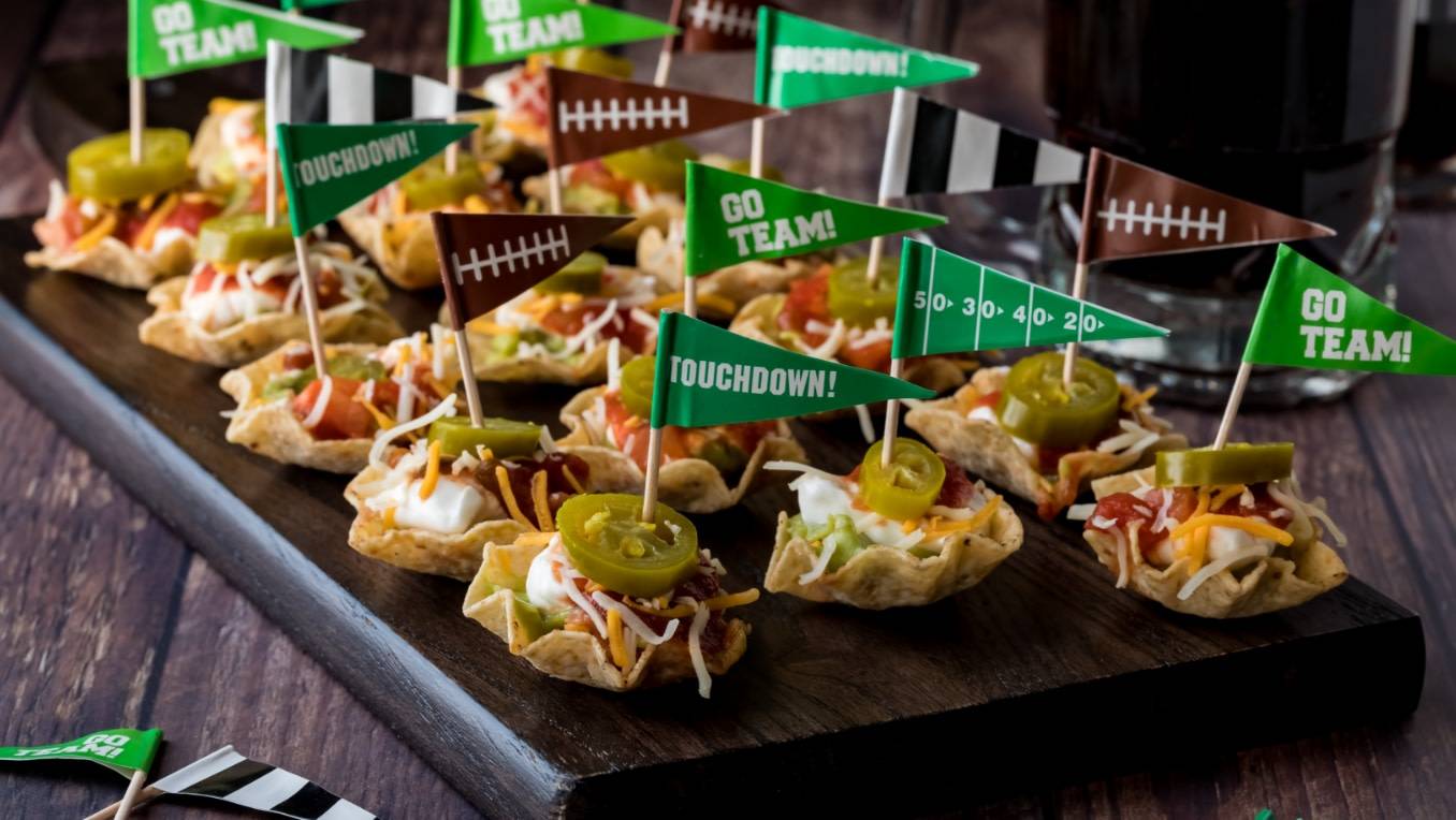 A photo of mini nacho bowls with small sports flags sticking out of them